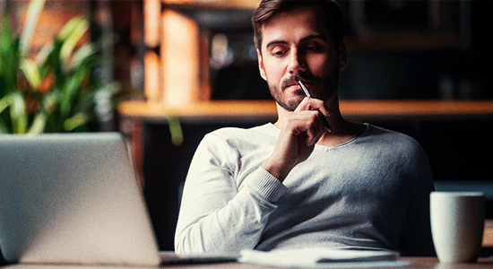 Homem com feição pensativa, em um escritório.